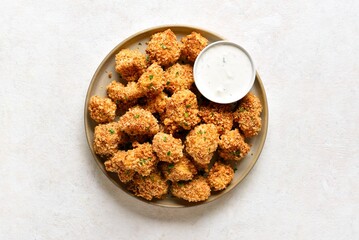 Crispy breaded oven baked cauliflower bites served with dipping sauce