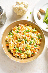 Cauliflower fried rice with carrot, green pea, corn, scrambled eggs in bowl