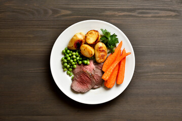 Sunday Roast with roasted beef, carrots, crispy potato, green pea and yorkshire pudding