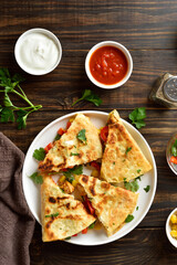Chicken quesadilla with fresh vegetables on wooden table