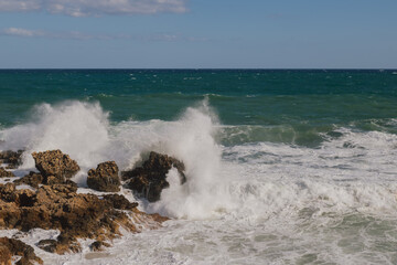 Mediterranean seascape during windy but sunny weather with waves breaking on the shore