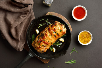 Roasted pork loin with rosemary and garlic in cast iron pan