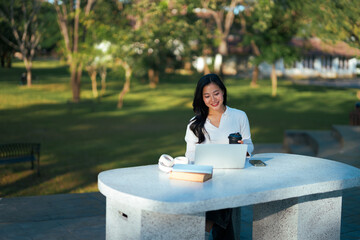 Woman working remotely on laptop in park