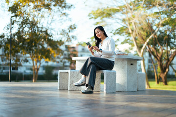 Young woman enjoying connection with smartphone in park