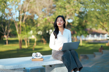Young woman working enjoying remote workday in park