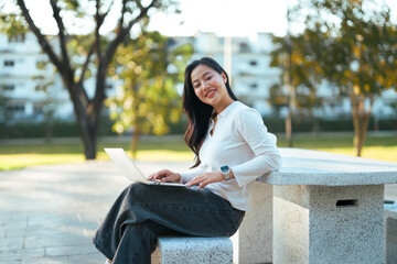 Woman working remotely on laptop in park