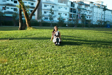 Asian woman relaxing outdoors in park enjoying sun