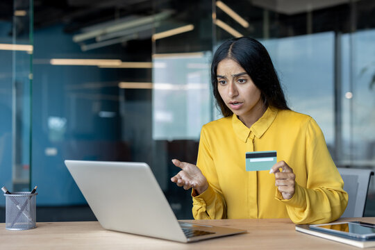 Problem with bill and credit card, Indian young woman in office looking worriedly at laptop screen - Powered by Adobe