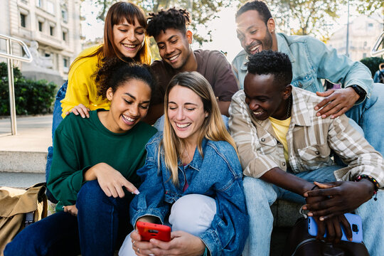 Multiracial young people having fun watching social media content on phone. Technology lifestyle and social media concept