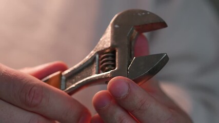 A male mechanic holds a wrench to fix a problem.
A metal adjustable wrench.
Mechanic's or mechanic's equipment.
Work, hand, mechanic, wrench, service, equipment