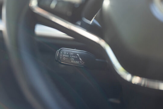 Cruise control buttons, speed limitation, car's signal. Close up of steering wheel of a new electric vehicle. Electric car control devices