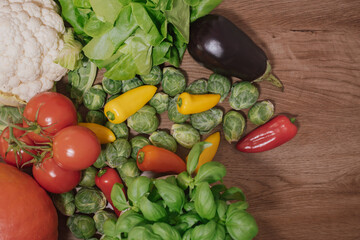 Fresh, colorful vegetables and greens on a wooden background with copy space