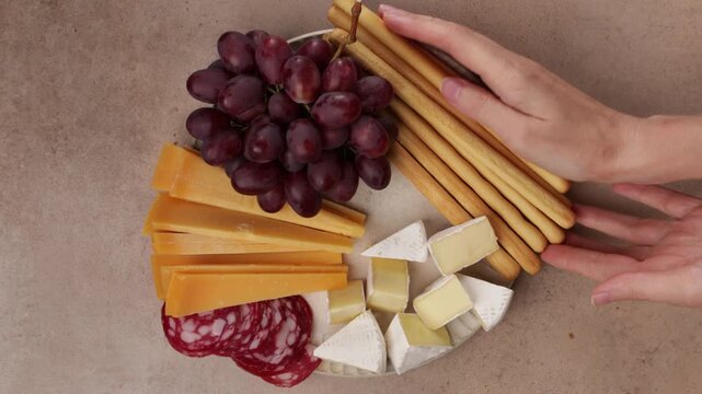 hands make cheese plate grapes figs and nuts on plate food zoom