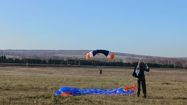 parachutists landing in the field
