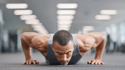 Motivated male athlete performing push-ups in a modern gym setting, showcasing strength and determination in fitness training 4k Video footage