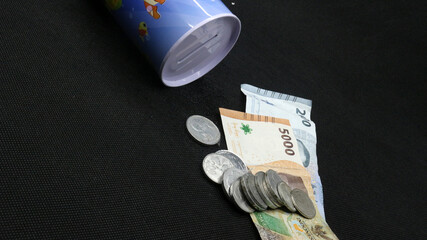 Piggy bank with scattered coins and bills