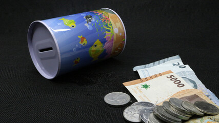 Piggy bank with scattered coins and bills