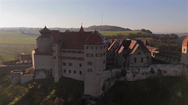 Drohnenbild der Burg Harburg im Sueden Deutschlands ueber dem Woernitz Tal im Noerdlinger Ries an einem klaren kalten Tag. Luftaufnahme von Burg Harburg auf dem Bergsporn ueber dem Woernitz Tal