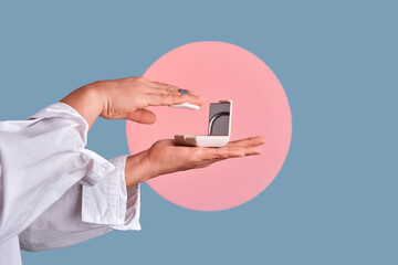 Hands applying face powder from compact case