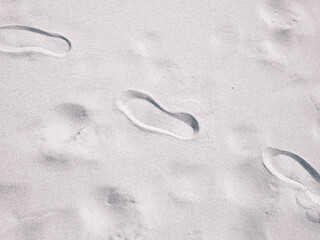 Travelers footstep on beach or desert.