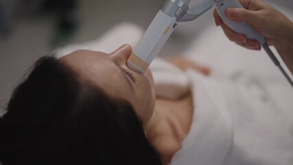 Closeup of female receiving focused ultrasound facial lifting procedure for skin tightening, promoting anti-aging and rejuvenation in professional cosmetology clinic. Concept of facial anti-aging.