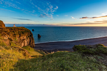 Stunningly beautiful sunset over the ocean as seen from the cape cliffs near the lighthouse of Vik, small city in Southern Iceland, travel tourist destination and sightseeing