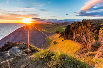 Stunningly beautiful sunset over the ocean as seen from the cape cliffs near the lighthouse of Vik, small city in Southern Iceland, travel tourist destination and sightseeing