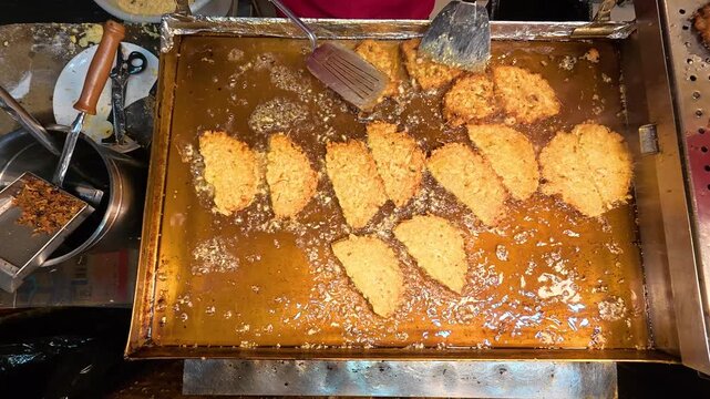 Vendor frying a Bindae-tteok or mung bean pancake at Gwangjang Market in Seoul