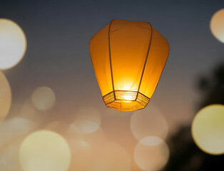 Asian sky lantern flying at orange sunset