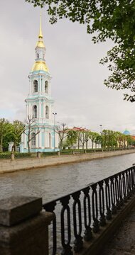 Russia, St.Petersburg, St.Nicholas cathedral, the embankment of the Kryukov Canal and the Griboyedov Canal, boats floating on the river, people strolling along the embankment