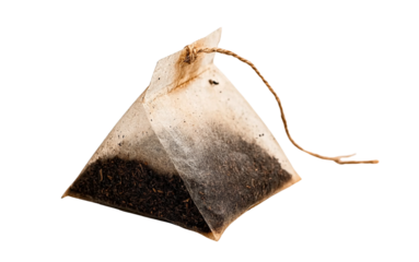 a tea bag with loose dark brown liquid inside, tied at the top and hanging from a string, isolated on a white background. detailed, high-quality photographic stock image with extremely sharp focus and