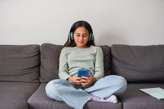 Young teenager girl using mobile phone while scrolling on social media - Technology, addiction and childhood concept