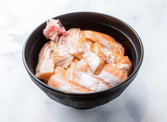 Enjoy fresh salmon donburi in a sleek black bowl with pickled ginger, perfect for healthy lunches or Japanese food promotions