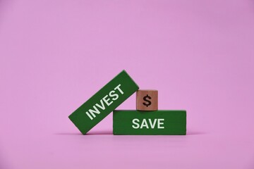 Pink background with green blocks reading INVEST and SAVE and a small dollar block, symbolizing budgeting, financial growth, and smart money management for wealth building.