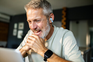 Mature man smiling on video call at home