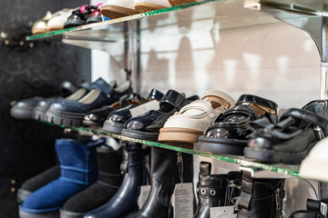 A variety of shoes neatly arranged on glass shelves in a retail store, showcasing different styles and colors for shoppers.