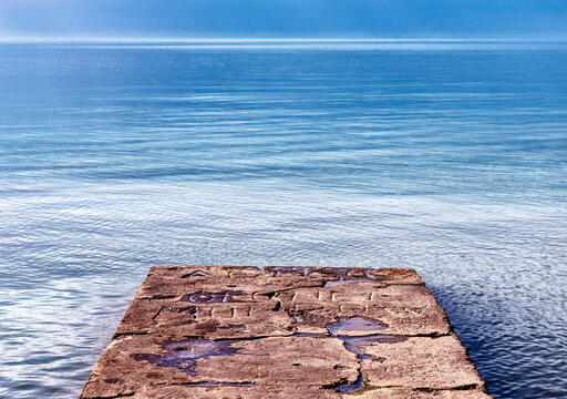 stone dock with sparkling blue water.