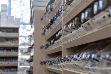 A close-up view of eyeglasses displayed on wooden shelves in an optical store, showcasing a variety of styles and frames.