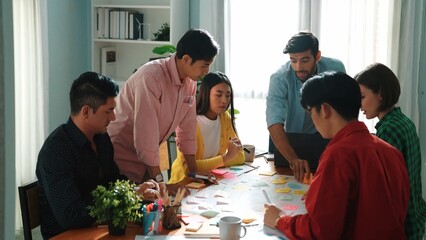 Top view of diverse business people drawing mind map by using marker while brainstorm idea and writing on sticky notes. Group of smart team sharing idea while planning creative strategy. Convocation.