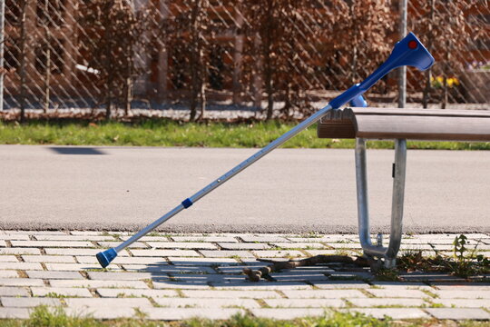 A blue cane is leaning against a bench - Powered by Adobe