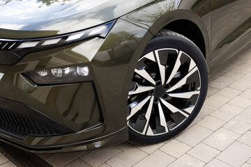 New electric vehicle front wheel. Modern electric car wheel. Close up tires on a road. Detail of...