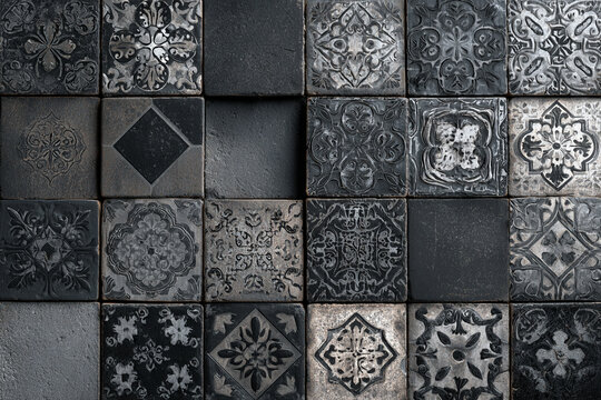 A close up of floral patterned tiles in black and white with a vintage distressed look