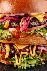 Close-up shot of a two-layer gourmet burger stacked with juicy beef patties, melted cheese, fresh onion slices, crisp lettuce, and rich red sauce.