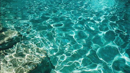 In a tranquil location sunlight dances on clear water revealing smooth stones beneath the surface. The scene conveys a soothing and peaceful ambiance.