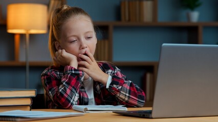 Sleepy Caucasian girl child kid daughter yawning studying online at home feeling tired yawn exhausted e-learning course sleepy watching virtual lesson learn study with internet bored at night evening