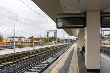 Train station platform with railroad tracks on a cloudy day
