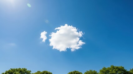 White fluffy cloud in clear blue sky above green trees