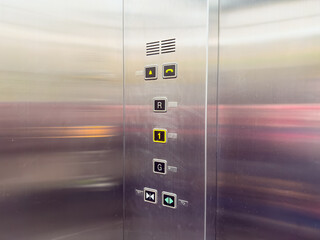 Close-up view of an elevator control panel showing floor buttons, door controls, and emergency indicators.