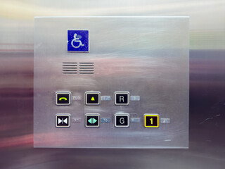 Close-up view of an elevator control panel featuring floor buttons, emergency functions, door controls, and a wheelchair accessibility symbol.