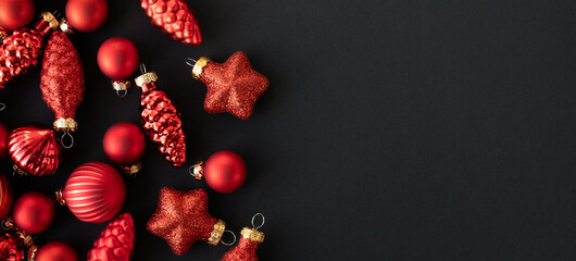 Red Christmas ornaments on black background, minimalist festive composition with copy space for holiday banners, greeting cards, winter sales and seasonal design projects